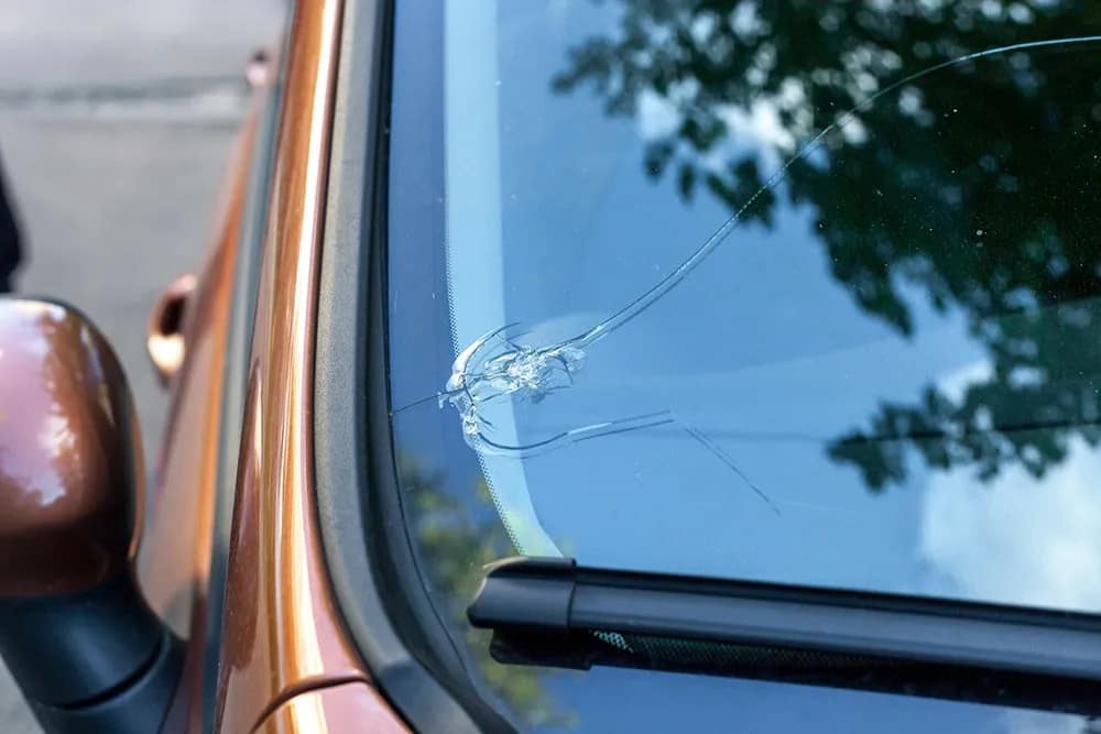 Close-up of a car windshield with cracks and chips requiring professional auto glass repair..jpg